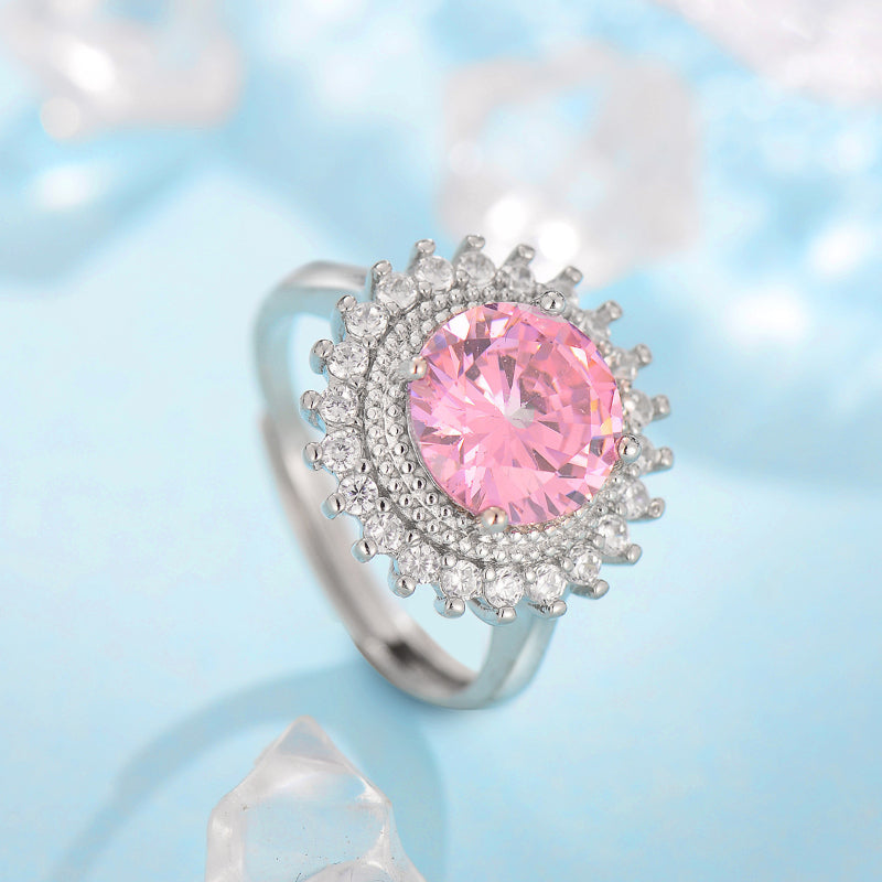 Ring with pink center stone and halo of clear crystals on silver band