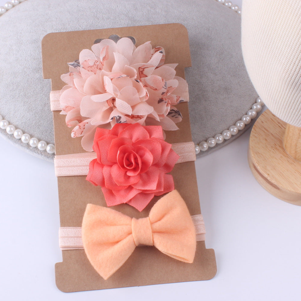 Three-piece floral baby stretch hairbands set featuring pink bloom, coral flower, and peach bow on soft elastic bands