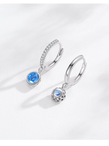 Pair of silver hoop earrings with sea blue stones; one pave-crystal hoop and one lattice-ball charm