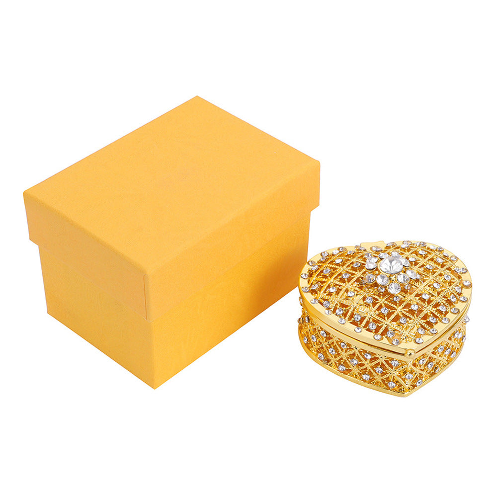 Heart-shaped gold-plated metal jewelry box with crystal lattice embellishments and a yellow gift box