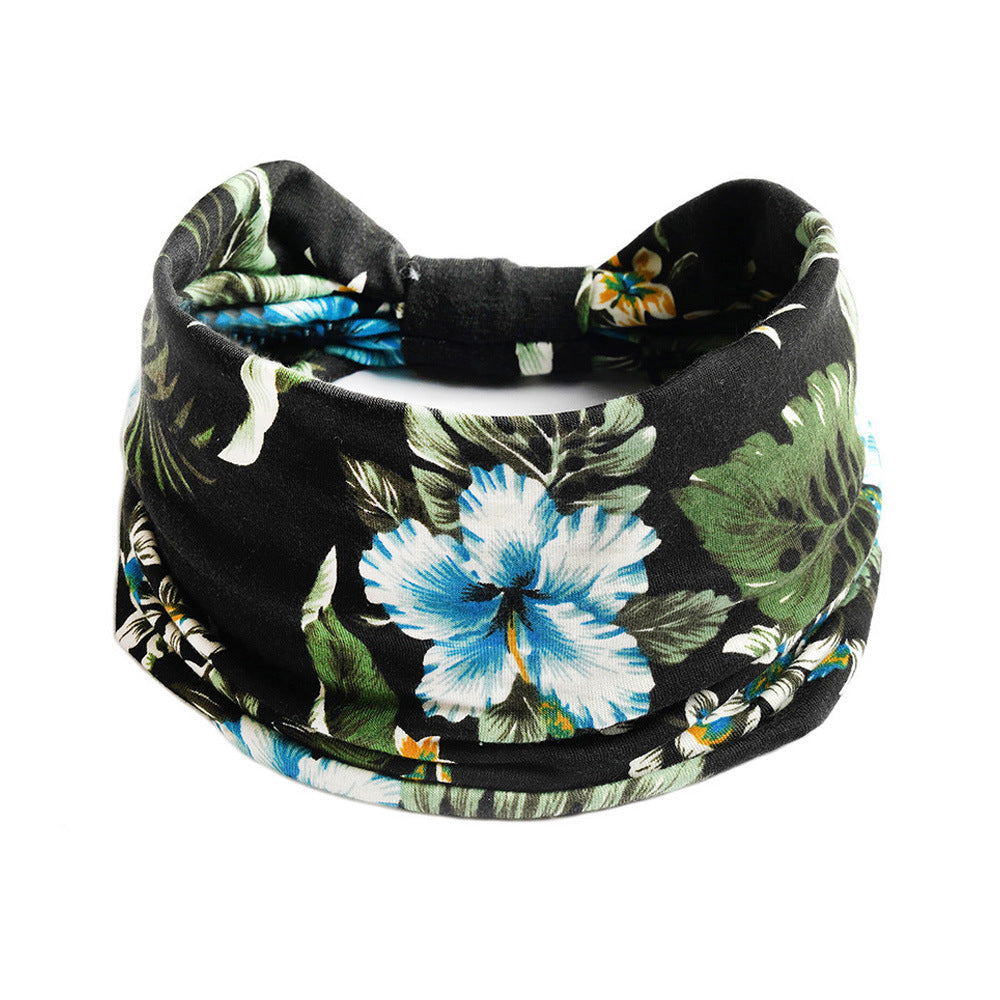 Bohemian floral yoga headband in black with blue hibiscus and green leaves; elastic, absorbent CJ brand