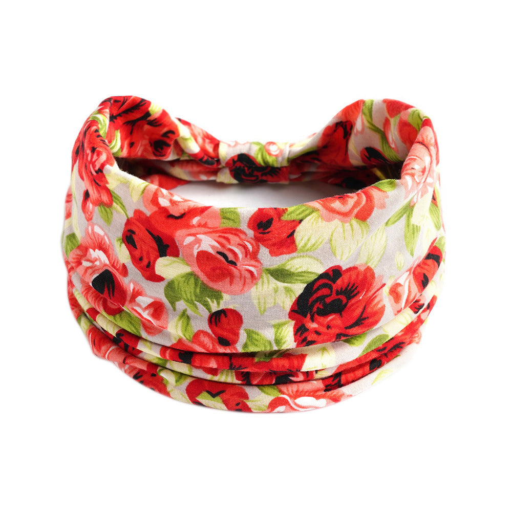 Yoga headband with red floral print and green leaves on white fabric