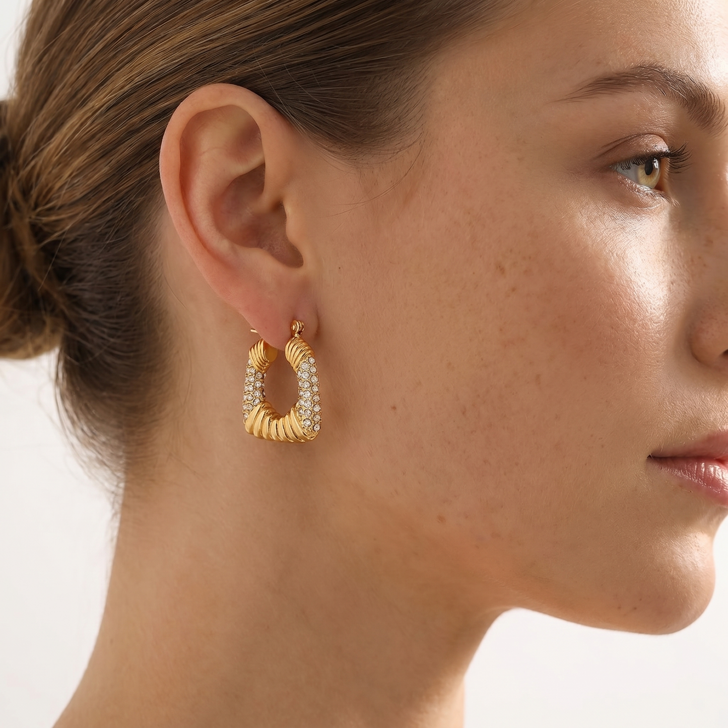 Geometric trapezoid hoop earrings in 18K gold-tone stainless steel with pavé cubic zirconia.